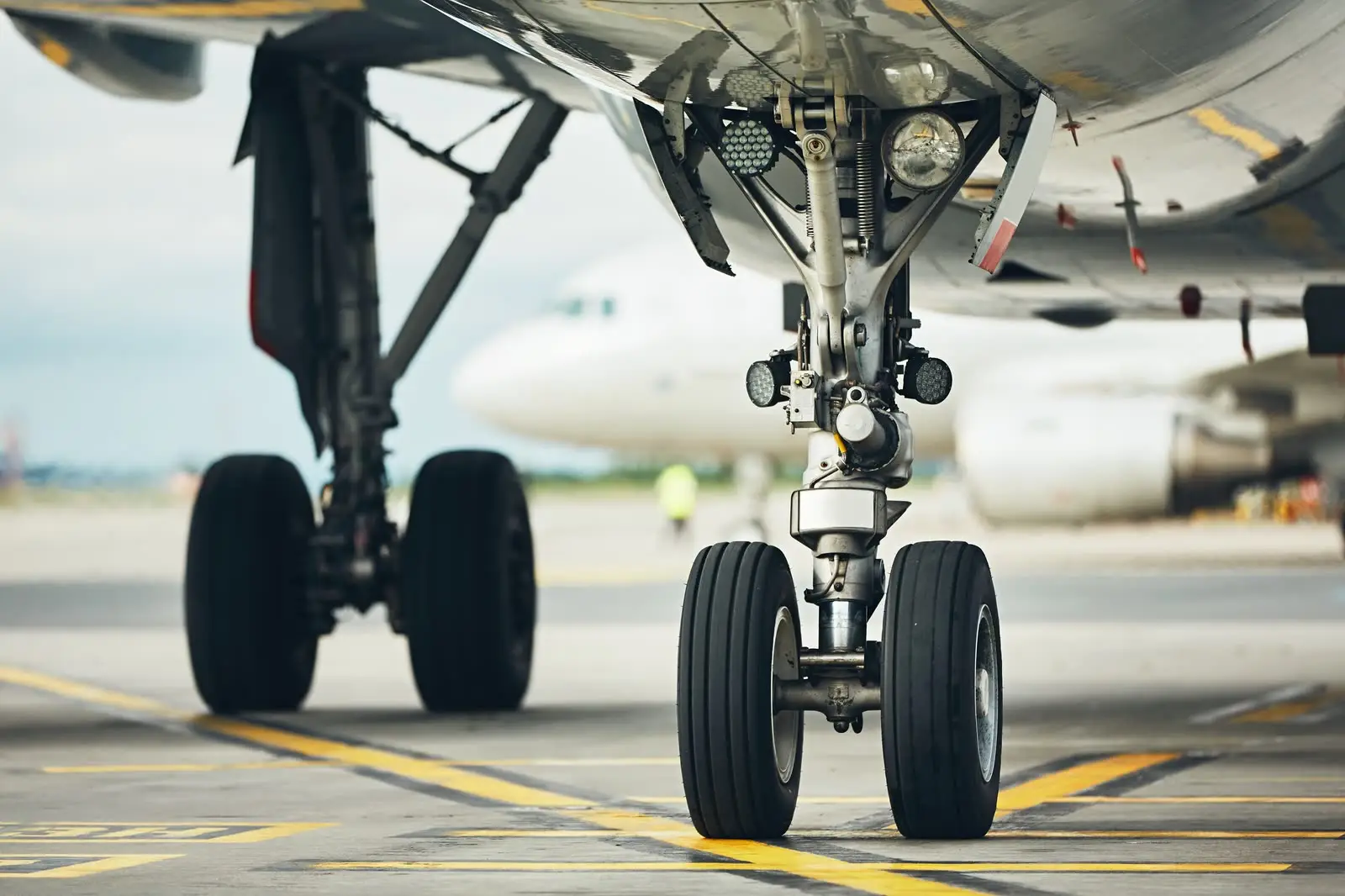 Airliner nose and main landing gear on an airport apron